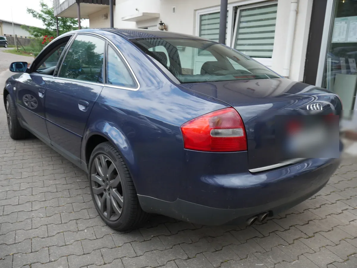 Audi A6 Vorschaden – Heck- und Seitenansicht links der dunkelblauen Limousine bei der Besichtigung, Kennzeichen unkenntlich