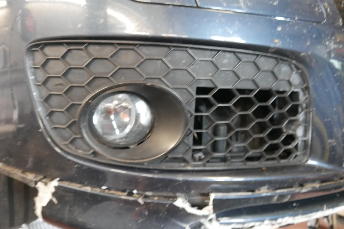 VW Golf V GTI – Stoßfänger am Nebelscheinwerfer gebrochen, Detailaufnahme der Schadenstelle an der Front