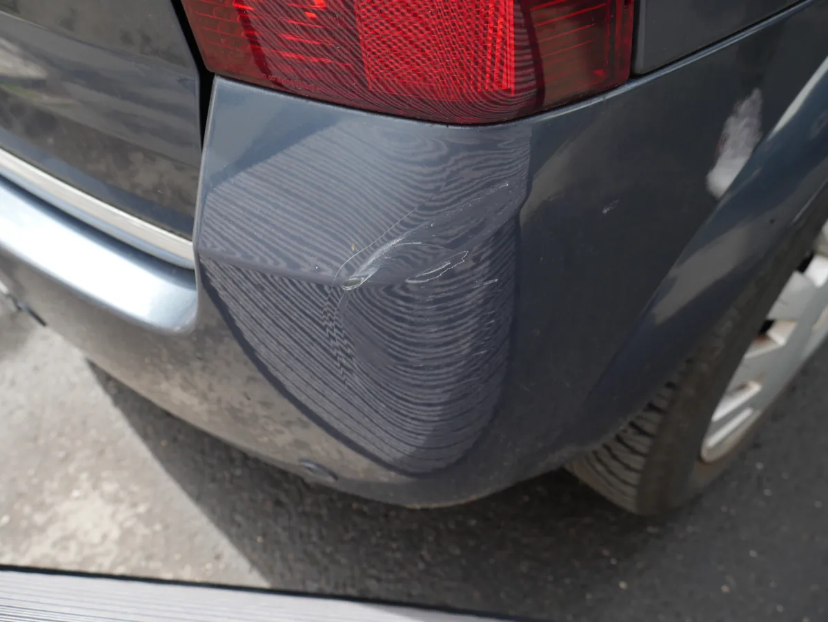 Opel Meriva – eingedellte Heckecke rechts, Detail der Verformung am Heckstoßfänger