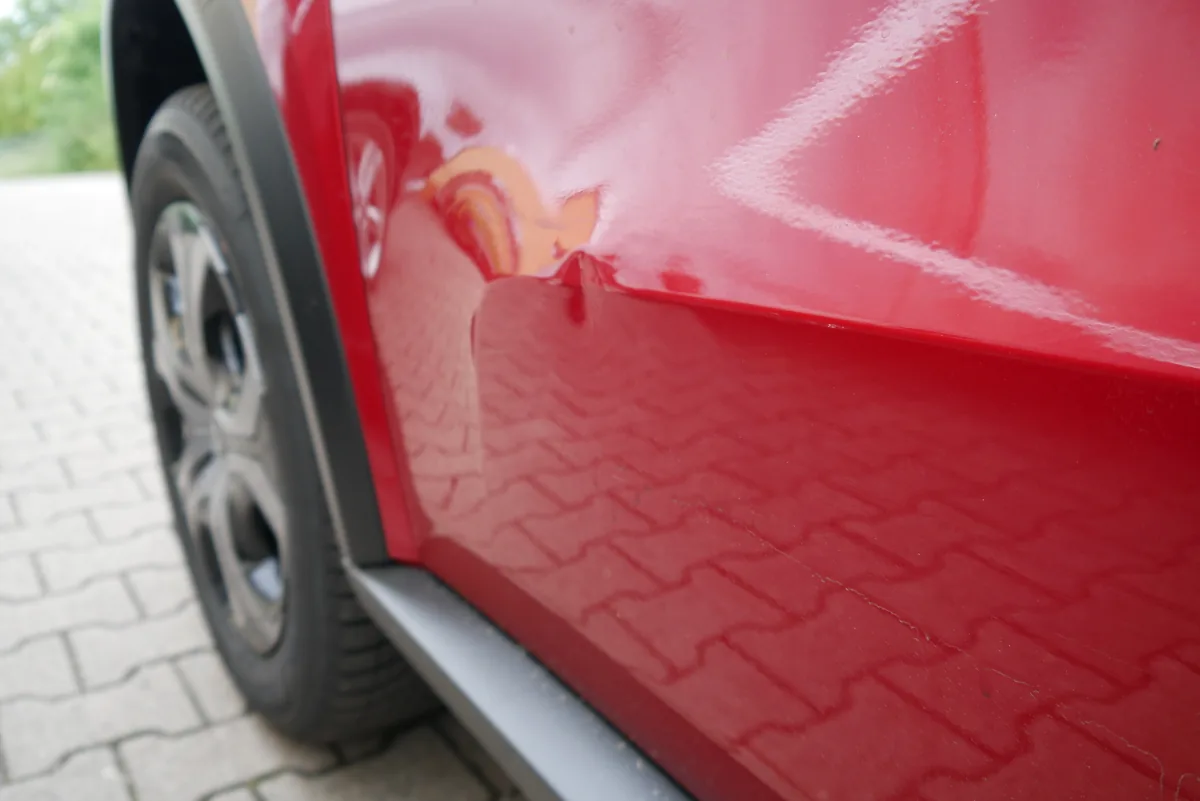 Citroën C3 Aircross Parkschaden – Delle in der Tür vorne links aus schräger Perspektive, Anstoßbereich