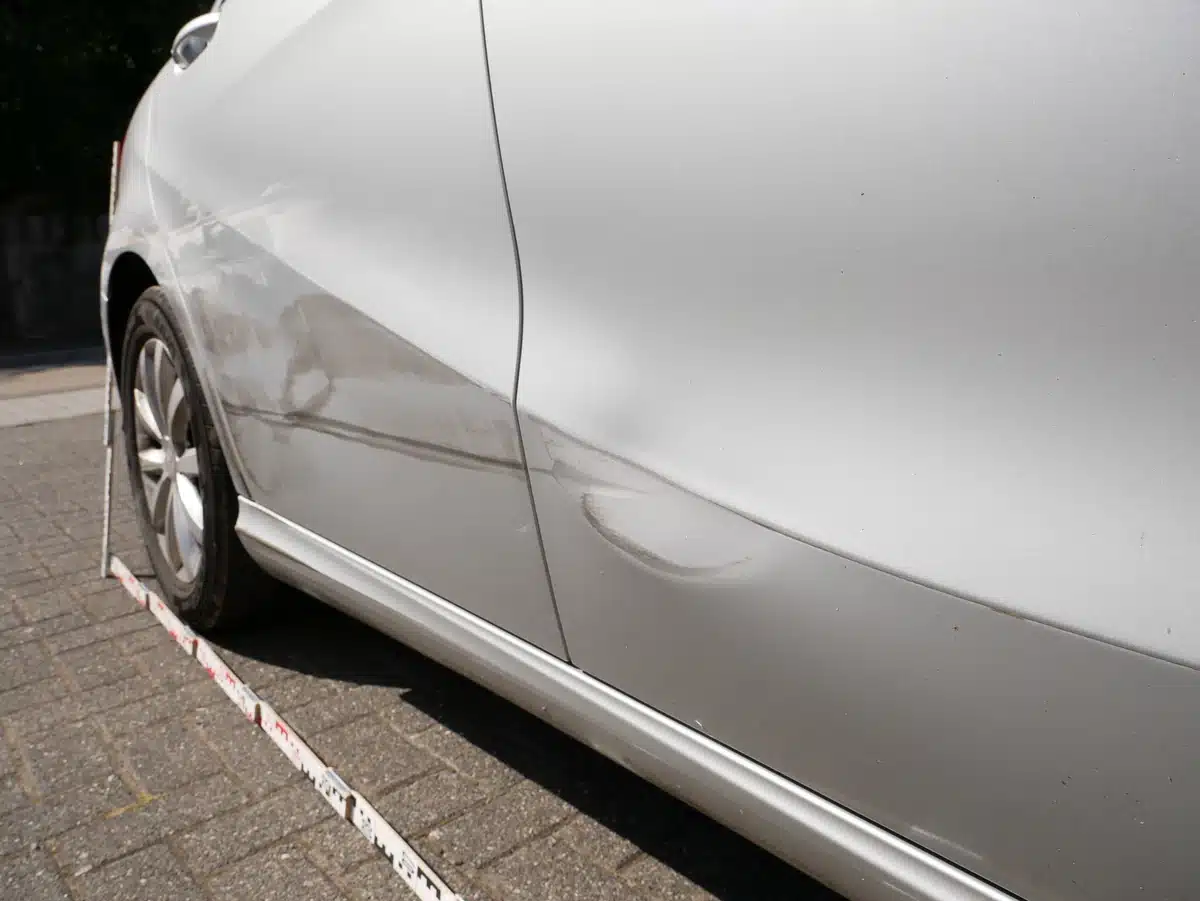 Mercedes A 180 Totalschaden: rechte Fahrzeugseite mit Eindellung und angelegter Messlatte zur Dokumentation