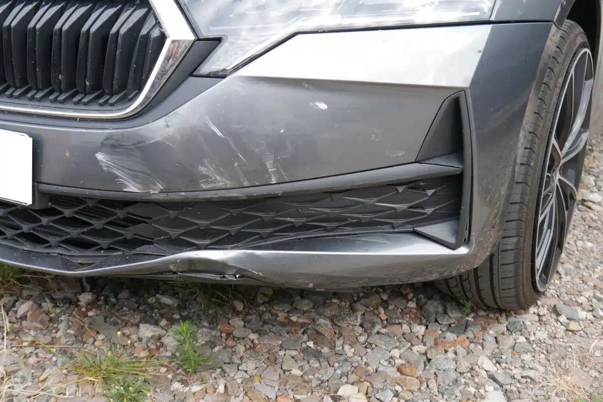 Detailaufnahme Sto&szlig;f&auml;ngerverkleidung vorn links &ndash; Frontschaden Skoda Octavia, Stauchung und Kratzfeld