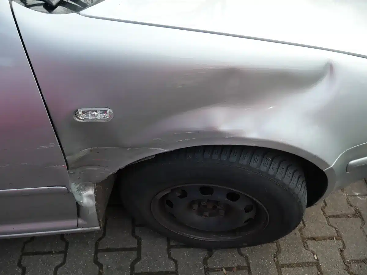 VW Golf IV – eingedrückter Kotflügel im Anstoßbereich, Detailaufnahme des Seitenschadens