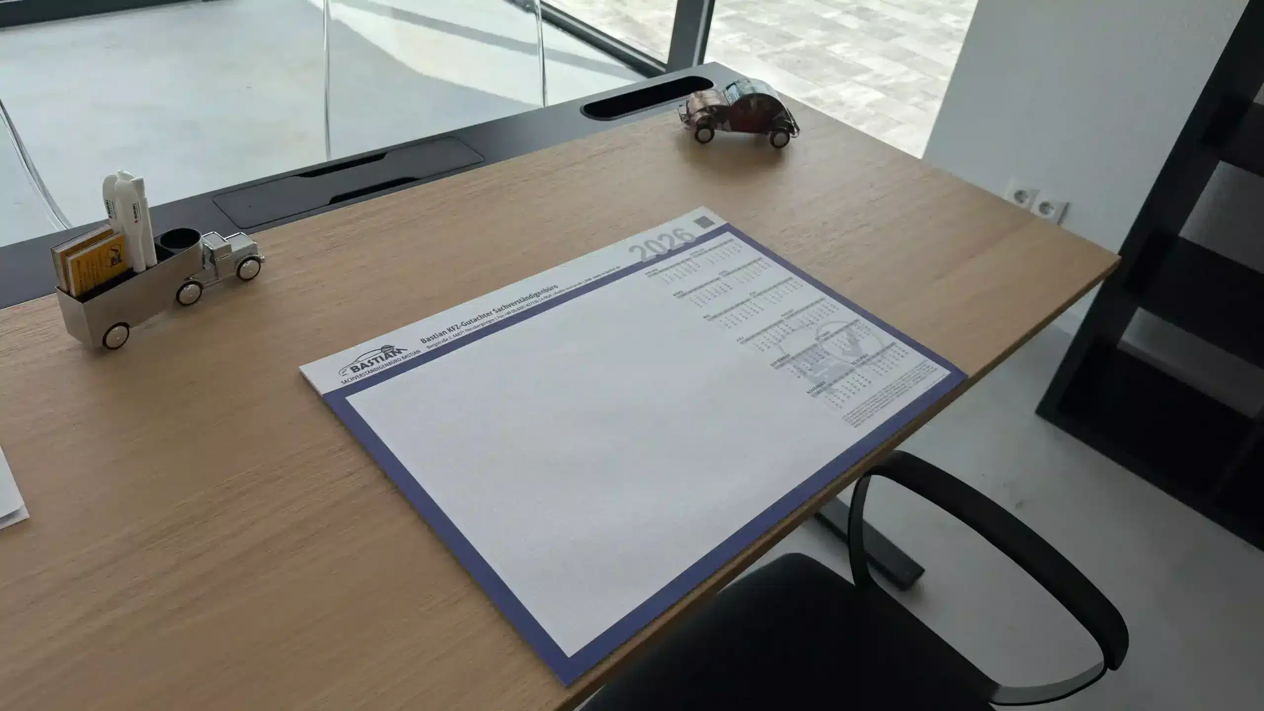 Schreibtisch im Sachverständigenbüro Bastian mit vollständigem Gutachten und Reparaturrechnung für den Auftraggeber